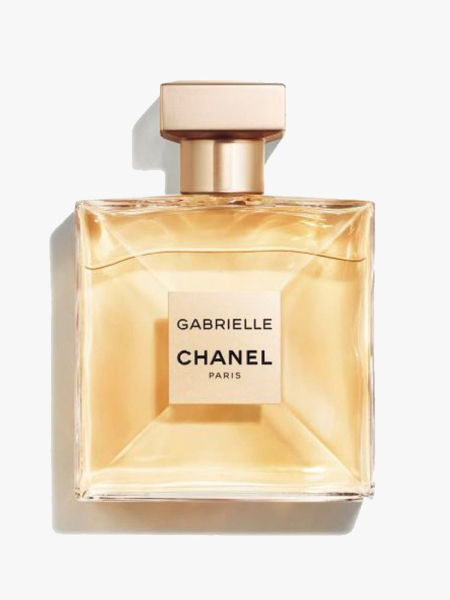 A glass perfume bottle with gold cap of the Chanel Gabrielle Eau de Parfum on a light gray background